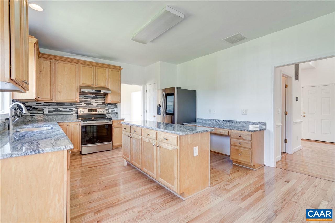 1280 Amber Ridge Road Charlottesville, VA 22901 - Photo 12 of 33 a large kitchen with stainless steel appliances a stove a sink dishwasher a refrigerator white cabinets and wooden floor next to a window