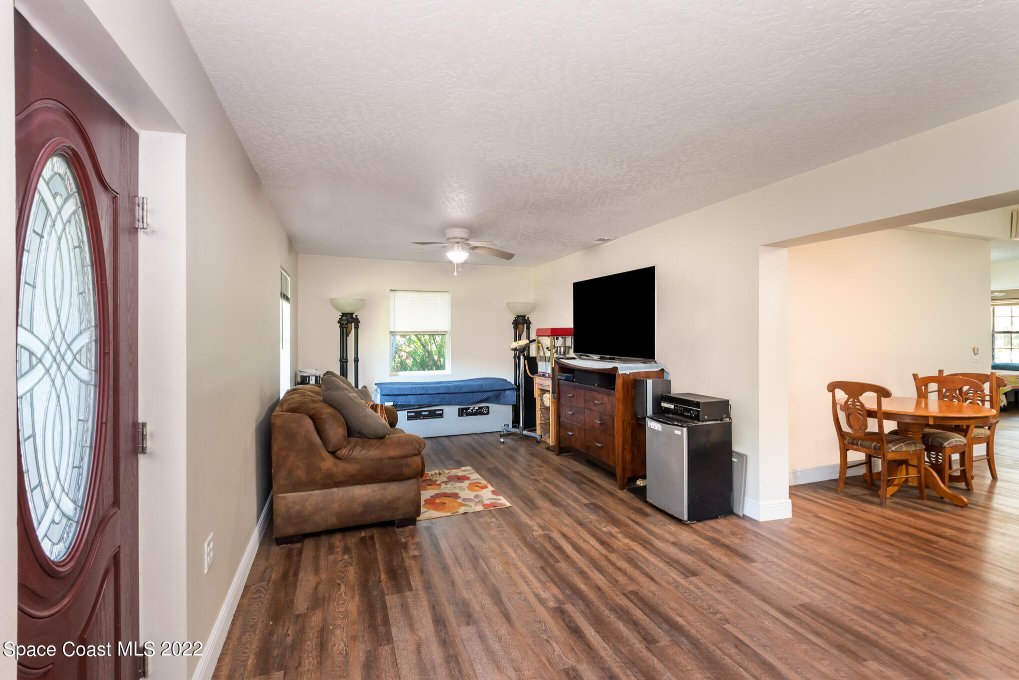 4275 Rayburn Road Cocoa, FL 32926 - Photo 6 of 26 a living room with furniture a flat screen tv and wooden floor