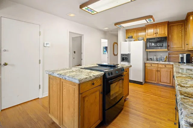 a kitchen with stainless steel appliances granite countertop a stove and a refrigerator