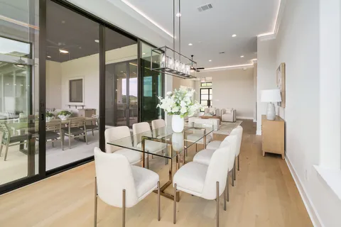 a dining room with furniture and a floor to ceiling window