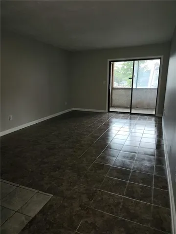 a view of a livingroom with a floor to ceiling window and wooden floor