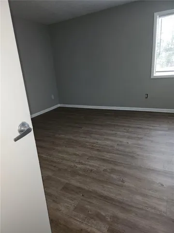 en empty room with wooden floor and windows
