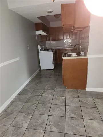 a room with a sink a stove and cabinets