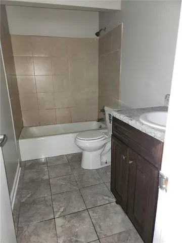 a bathroom with a granite countertop bathtub and a toilet