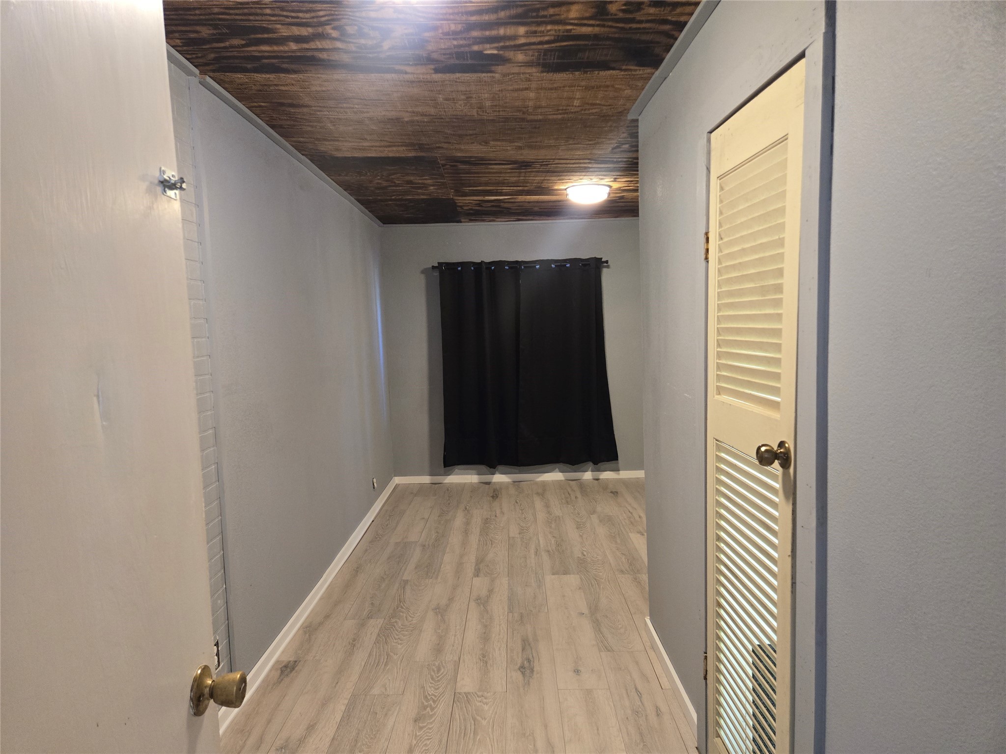 1045 Vine Drive Angleton, TX 77515 - Photo 20 of 42 a view of a hallway with wooden floor and a bathroom