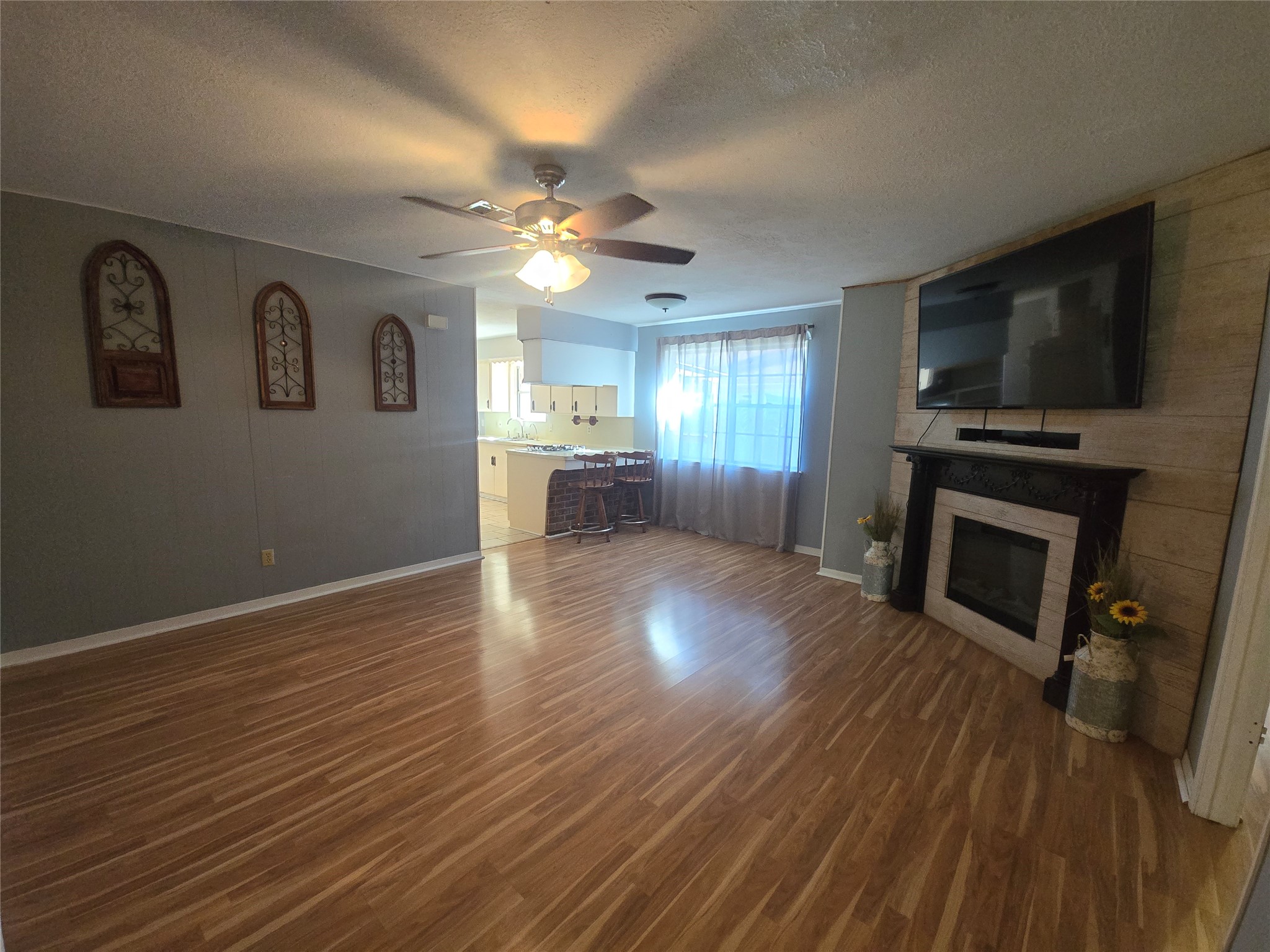 1045 Vine Drive Angleton, TX 77515 - Photo 27 of 48 a view of a kitchen with furniture a ceiling fan and wooden floor
