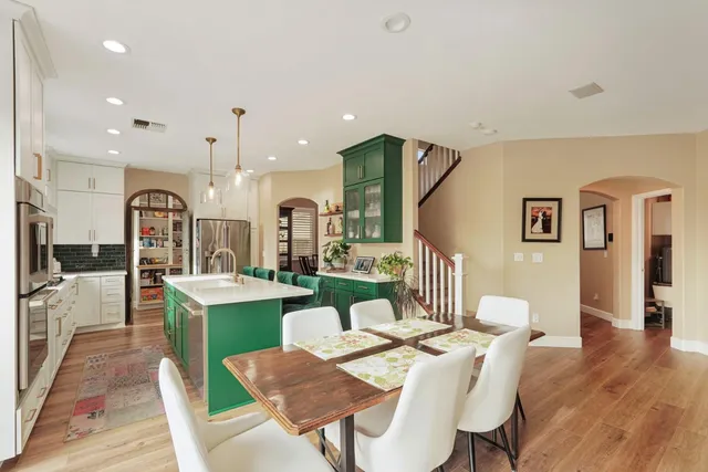 a kitchen with a table chairs refrigerator and microwave