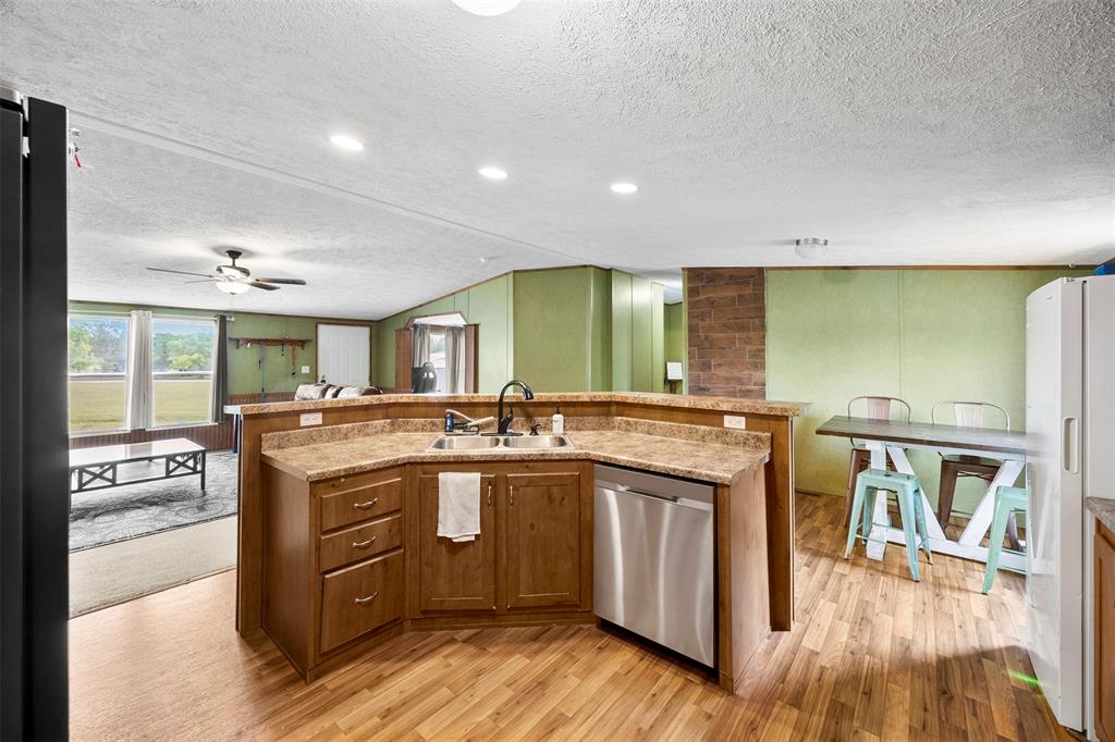 10020 Lavender Road Crowley, TX 76036 - Photo 29 of 29 Kitchen featuring an island with sink, open floor plan, light wood-style flooring, freestanding refrigerator, and dishwasher