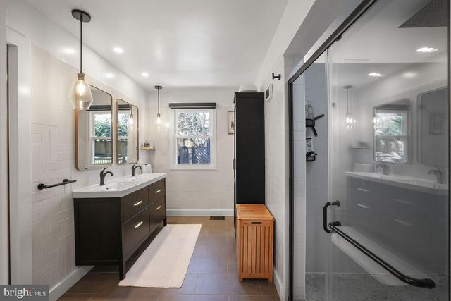 a living room with couches and a flat screen tv with kitchen view