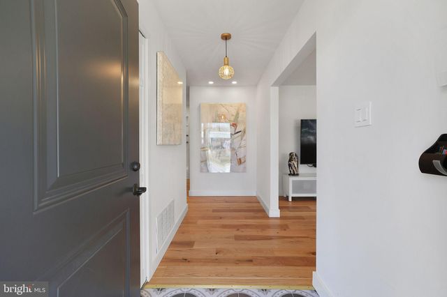 a view of a hallway with wooden floor and a living room
