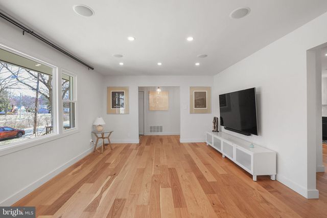 a view of a livingroom with wooden floor and a flat screen tv