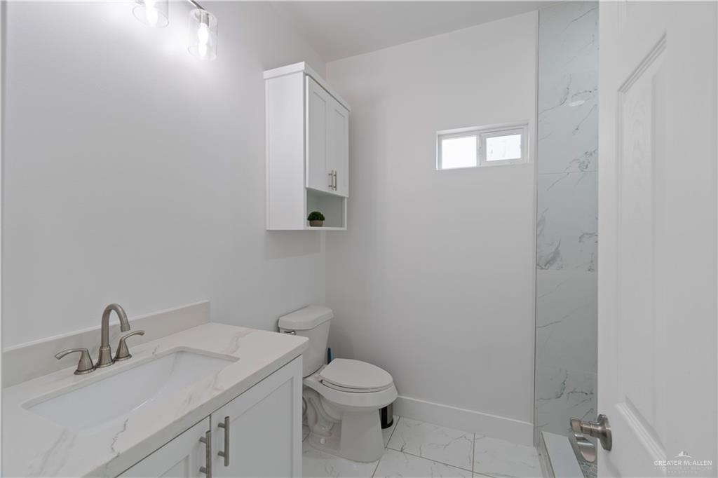 23232 Val Verde Road Edcouch, TX 78538 - Photo 8 of 19 a bathroom with a toilet sink vanity and mirror