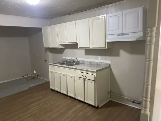 a kitchen with granite countertop white cabinets and a stove