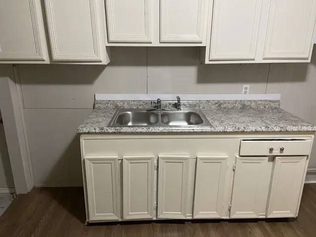a kitchen with granite countertop a sink and cabinets