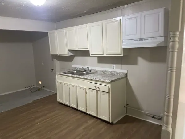 a kitchen with granite countertop white cabinets and a stove