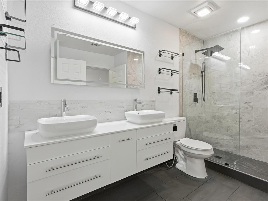 3801 14th Street, Unit 1302 Plano, TX 75074 - Photo 22 of 25 a bathroom with a double vanity sink toilet and shower