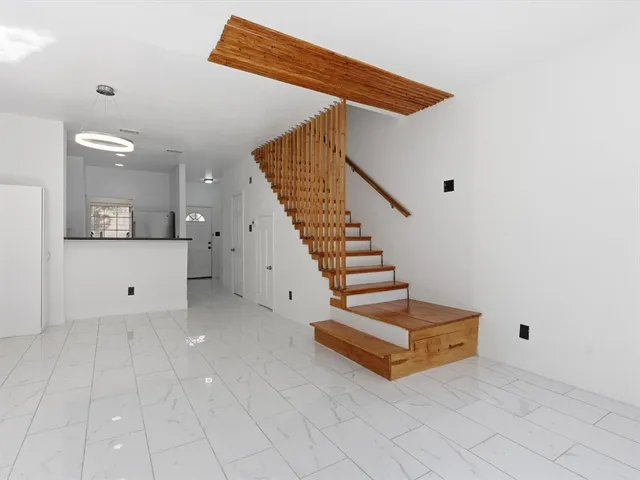 a view of an empty room with stairs and a fireplace