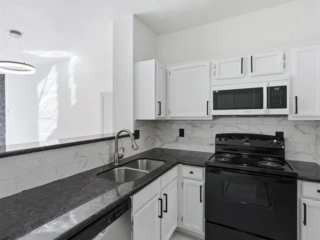 a kitchen with stainless steel appliances granite countertop a sink stove and cabinets