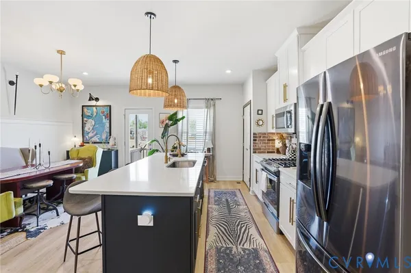 a kitchen with kitchen island a counter top space appliances and cabinets