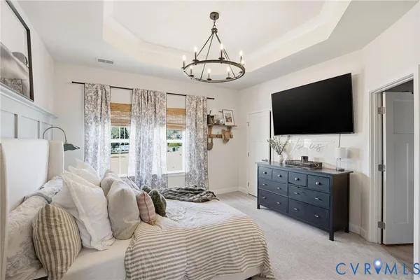 a bedroom with a bed television and a large window