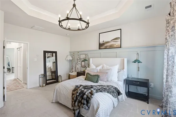 a bedroom with bed and a chandelier