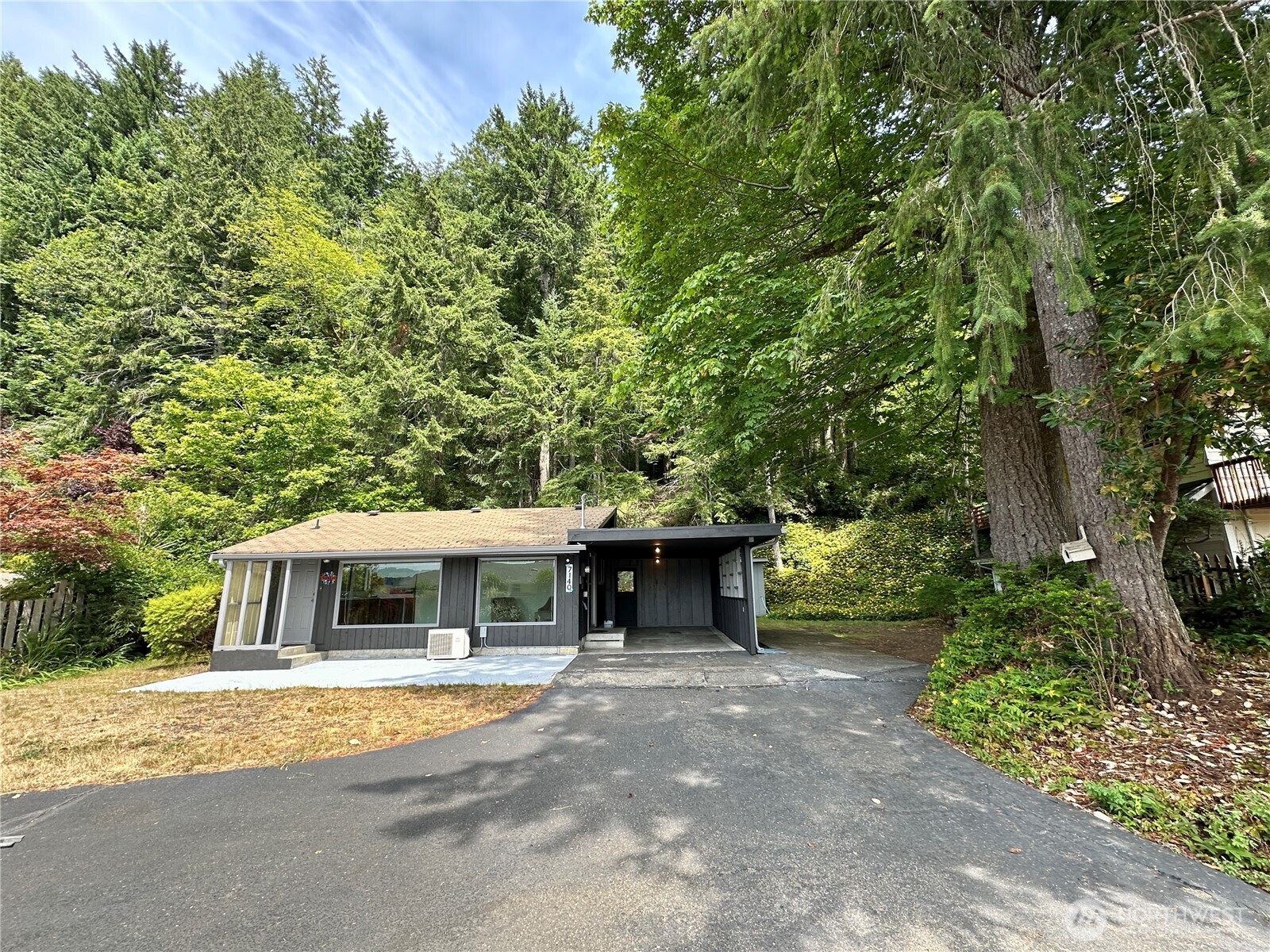 7140 Northeast North Shore Road Belfair, WA 98528 - Photo 2 of 31 a front view of a house with a garden and trees