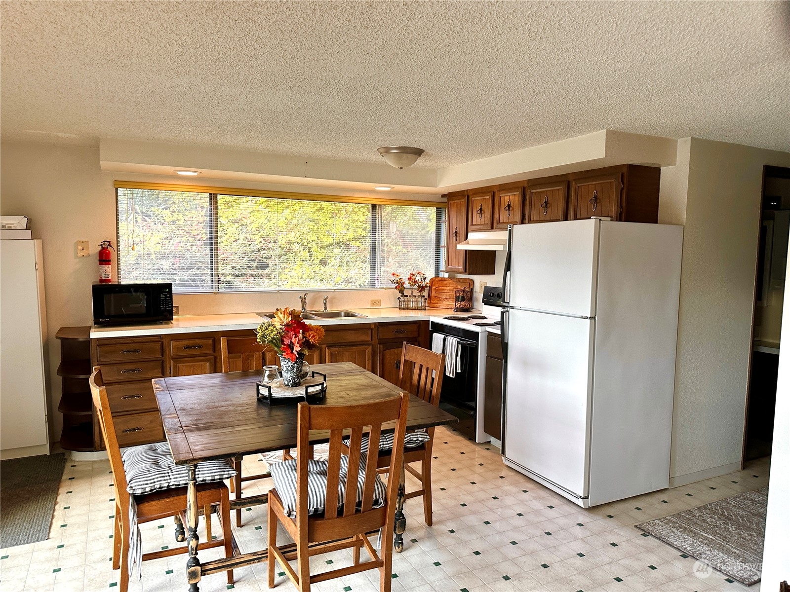 7140 Northeast North Shore Road Belfair, WA 98528 - Photo 10 of 31 a dining room with furniture a large window and a refrigerator