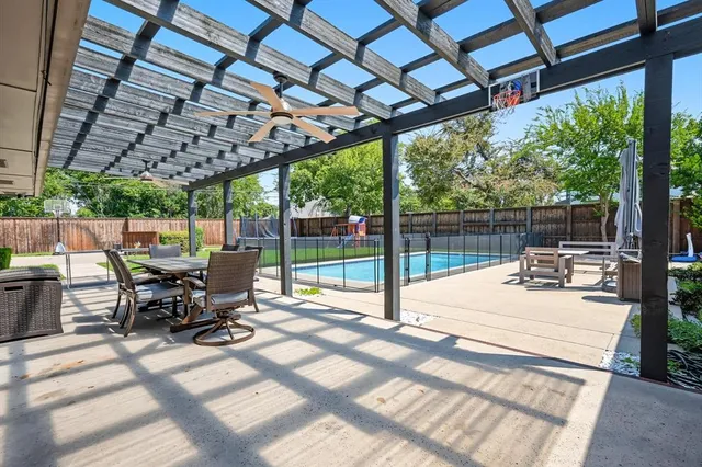 a view of a patio with a table and chairs in front of a yard