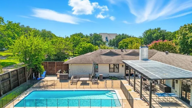 a view of a patio with table and chairs under an umbrella with wooden fence