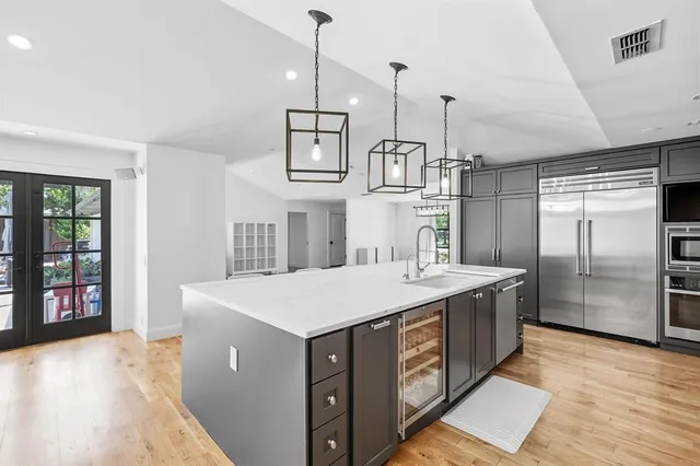 a kitchen with a stove a refrigerator a sink and dishwasher with wooden floor