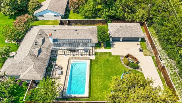 an aerial view of a house with swimming pool and big yard