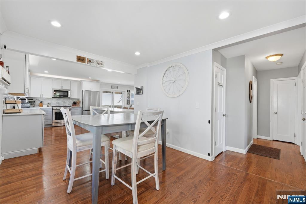 44 Alpine Place Kearny, NJ 07032 - Photo 23 of 50 a kitchen with stainless steel appliances a dining table chairs and wooden floor