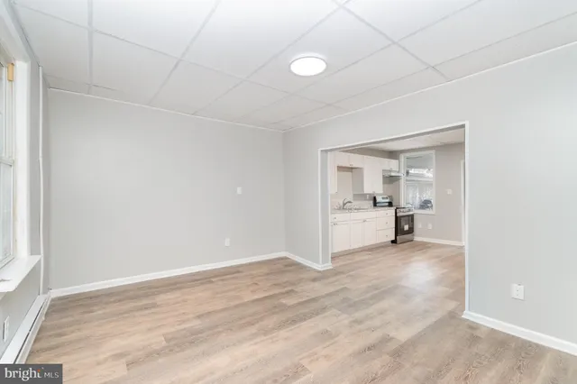 an empty room with white cabinet and mirrors