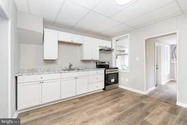 a kitchen with granite countertop a sink and a stove top oven