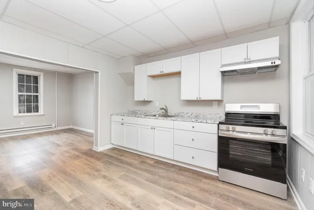 a kitchen with granite countertop white cabinets and appliances