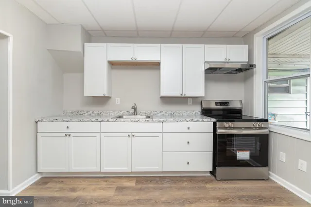 a kitchen with stainless steel appliances granite countertop a sink and a stove