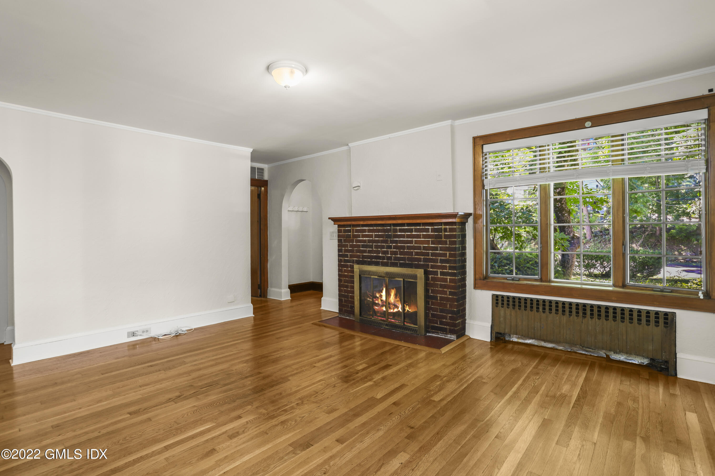 261 Pemberwick Road Greenwich, CT 06831 - Photo 6 of 13 wooden floor fireplace and windows in an empty room