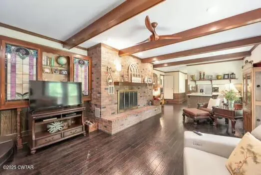 a living room with furniture a flat screen tv and a floor to ceiling window