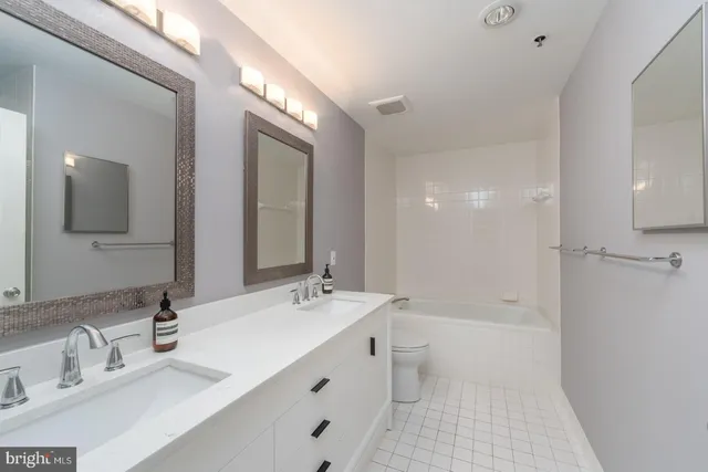 a bathroom with a double vanity sink mirror double and bathtub