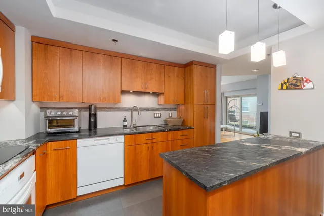 a kitchen with stainless steel appliances granite countertop a sink a stove cabinets counter space and a window