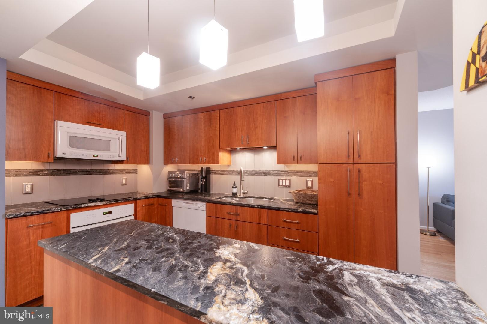 960 Fell Street, Unit 603 Baltimore, MD 21231 - Photo 3 of 24 a kitchen with stainless steel appliances granite countertop sink stove refrigerator and cabinets