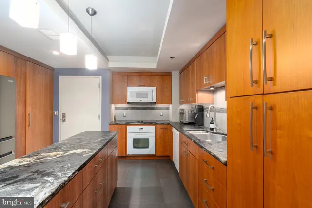 a kitchen with stainless steel appliances granite countertop a stove a sink and a refrigerator