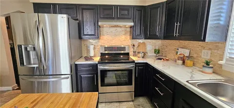 a kitchen with a sink and stainless steel appliances