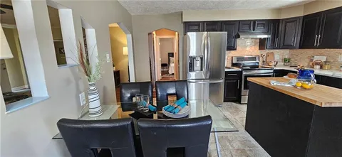 a kitchen with stainless steel appliances granite countertop a refrigerator and a stove