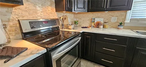 a kitchen with granite countertop a stove and a sink