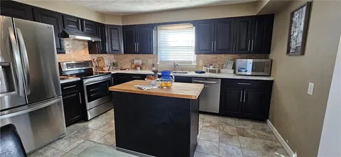 a kitchen with a sink stove and refrigerator