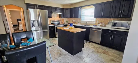 a kitchen with stainless steel appliances granite countertop a refrigerator and a sink