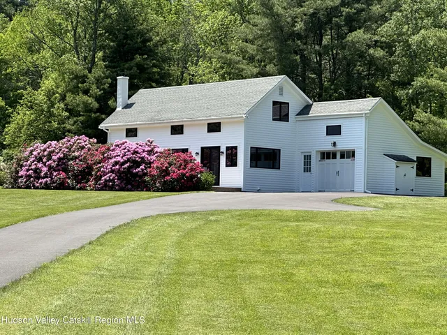 a front view of a house with a yard and fountain