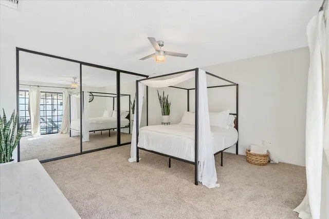 a spacious bedroom with a bed and a chandelier