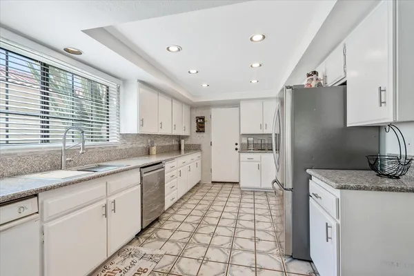 a kitchen with a sink a refrigerator and window